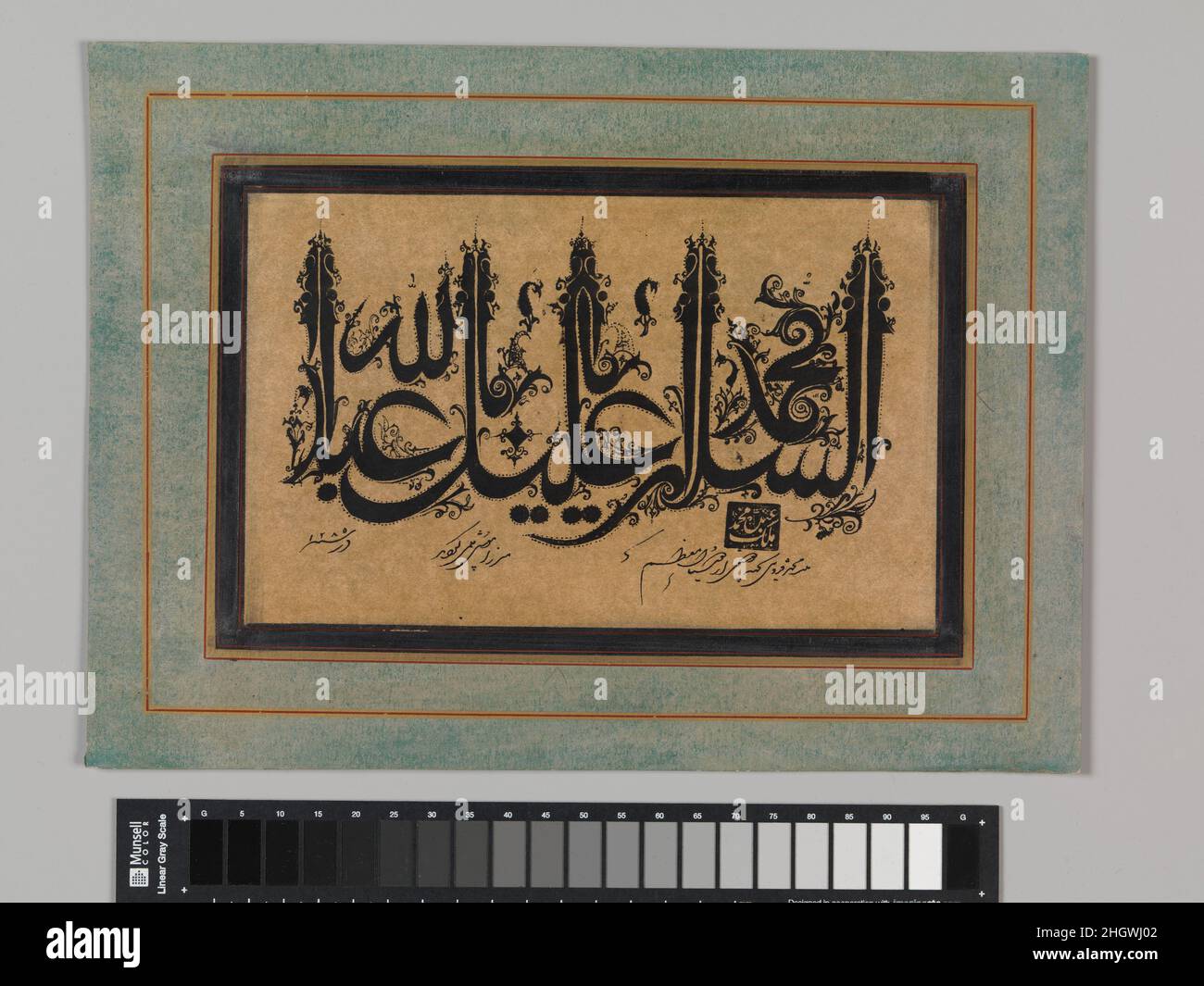 Page of Calligraphy in Ornamental Style dated A.H. 1285/A.D. 1868–69 Malik Muhammad Qazvini Iranian This bold and ornate sample of calligraphy invokes blessings on the Prophet Muhammad ('Peace be upon you, Oh Muhammad, servant of God'), placing the words of the upper line between the tall vertical shafts of the lower line. The calligrapher, Malik Muhammad Qazvini, penned this piece for an honored friend, Mirza Musa. The style is a nineteenth-century adaptation of medieval floriated kufic, in which floral terminals and dotted outlines embellish each letter. An inscription in three parts under t Stock Photo