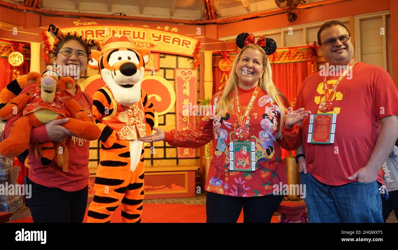 Anaheim, USA. 22nd Jan, 2022. Visitors pose for photos with the cartoon character Tigger during the Lunar New Year celebrations at Disney's California Adventure Park in Anaheim, the United States, on Jan. 21, 2022. Disney's California Adventure Park kicked off celebrations of the Year of the Tiger Friday, featuring a string of Chinese culturally-themed performances, art shows, lantern decorations and Asian-inspired dishes. Credit: Zeng Hui/Xinhua/Alamy Live News Stock Photo