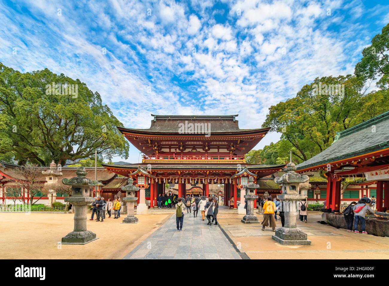 tokyo, japan - december 07 2019: Tourists walking along the sandō pathway surrounded by kasuga stone lantern leading to the two-storied Rōmon gate of Stock Photo