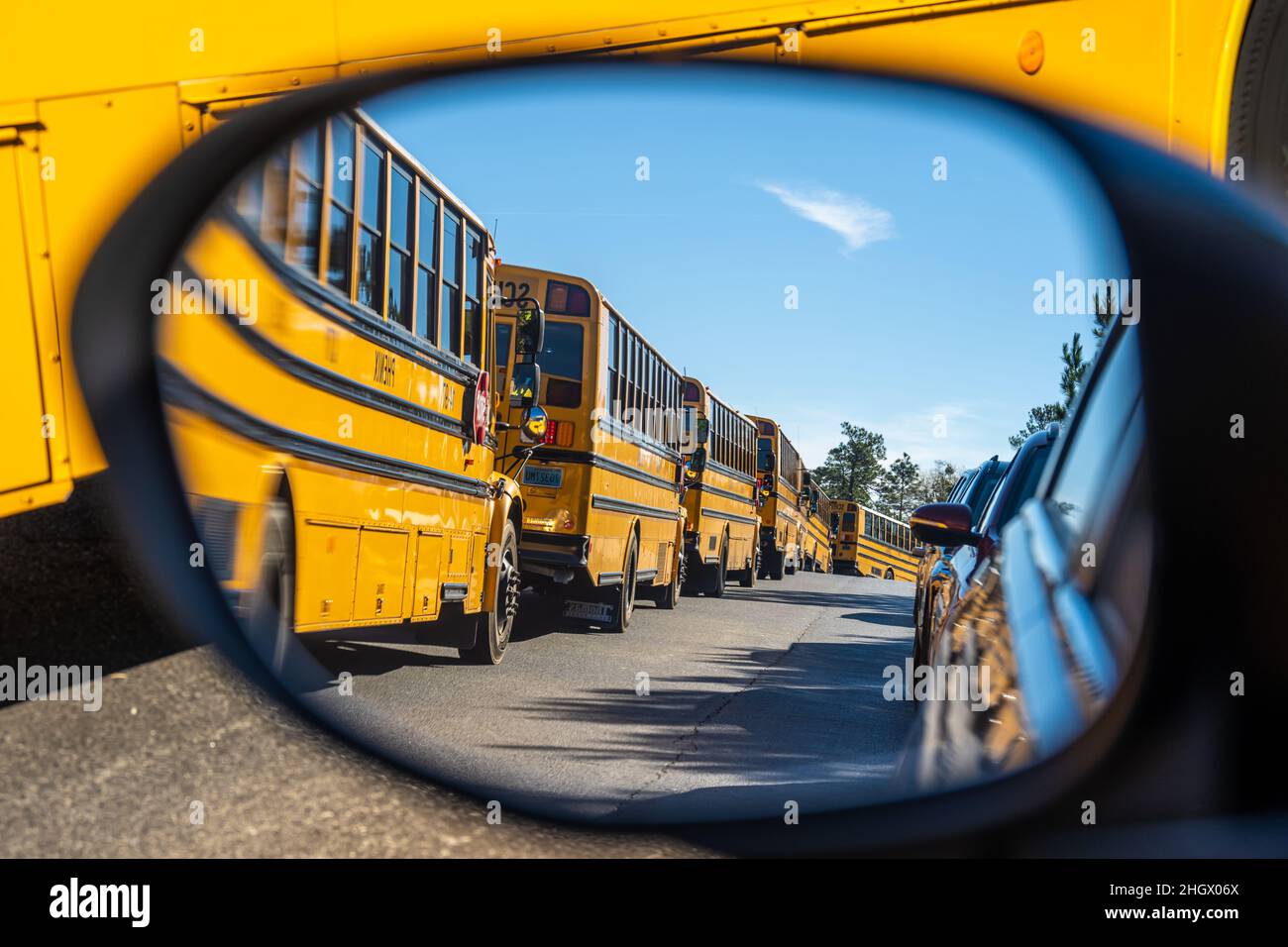 A row of yellow school buses and a parent car line at a Phenix City, Alabama, elementary school. (USA) Stock Photo