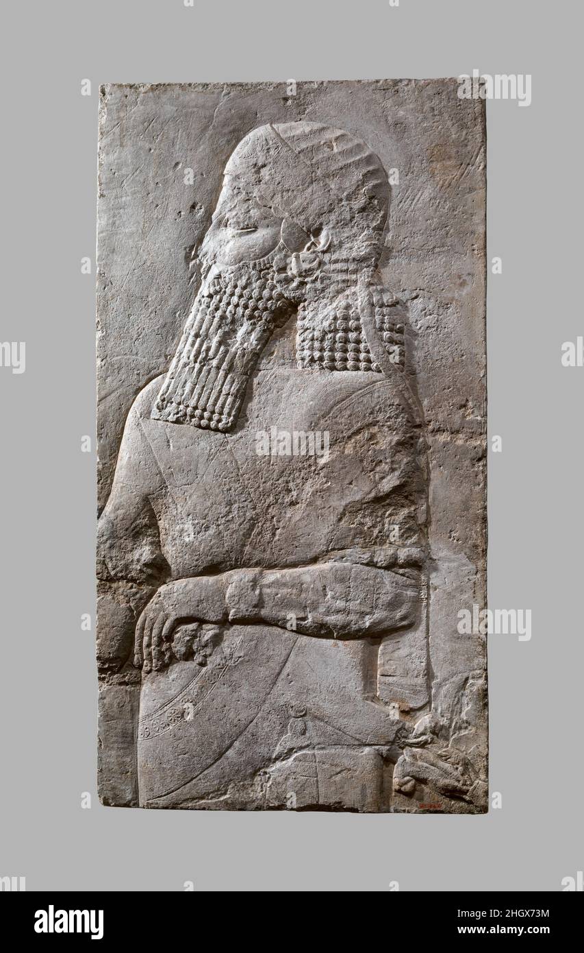 Assyrian Crown-Prince ca. 704–681 B.C. Assyrian This relief fragment dates to the time of Sennacherib (r. 704-681 B.C.), and comes from the great Southwest Palace, called by Sennacherib the 'Palace Without Rival,' at Nineveh. It originally formed part of a procession scene, and depicts in low relief the upper part of a male figure whose beard, clothing, and jewelry indicate particularly high status. His diadem, with incised decoration representing embroidered rosettes and a thin length of fabric running from its back, is an attribute often associated in this period with the Assyrian crown-prin Stock Photo
