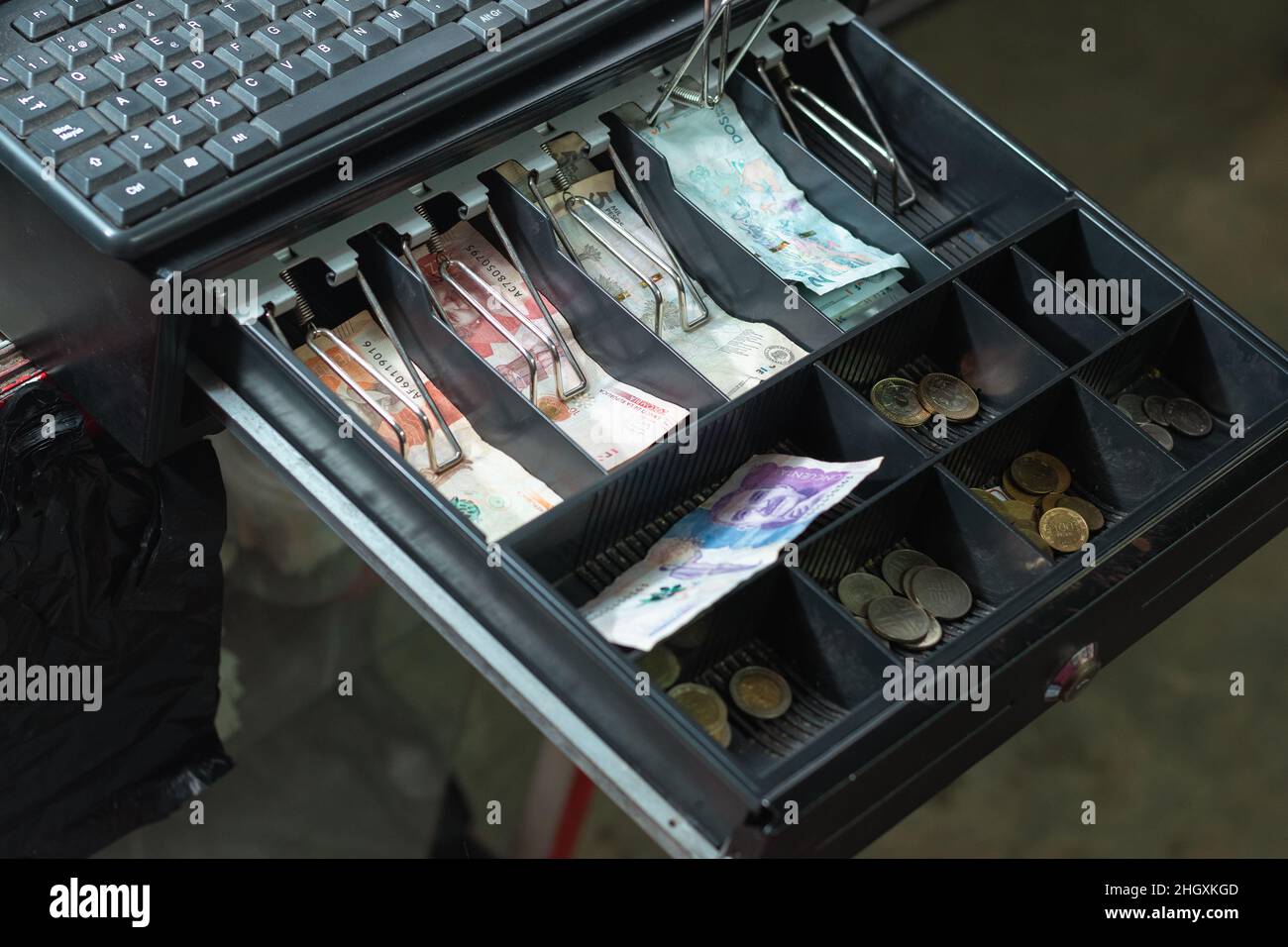 open cash register with keypad on top, in a colombian neighborhood store. cash register to keep money for business open with colombian bills and coins Stock Photo
