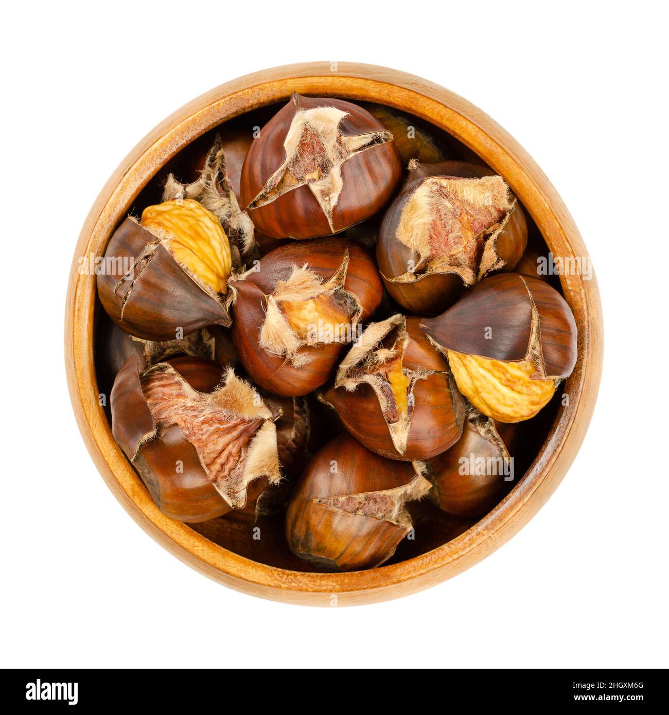 Freshly roasted chestnuts, in a wooden bowl. Popular autumn and winter street food in East Asia, Europe, and New York City. European sweet chestnuts. Stock Photo