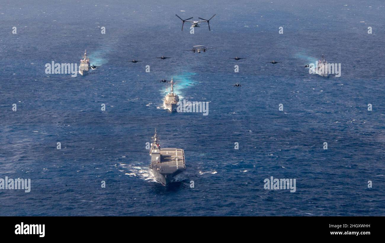 220122-N-PQ495-1485 PHILIPPINE SEA (Jan. 22, 2022) Aircraft assigned to Carrier Air Wing (CVW) 2 and CVW 9 fly over the Philippine Sea as Ticonderoga-class guided-missile cruiser USS Mobile Bay (CG 53), Arleigh Burke-class guided-missile destroyer USS Chafee (DDG 90), JMSDF Hyuga-class helicopter destroyer JS Hyuga (DDH 181) and Ticonderoga-class guided-missile cruiser USS Lake Champlain (CG 57) transit the Philippine Sea Jan. 22, 2022. Operating as part of U.S. Pacific Fleet, units assigned to Carl Vinson and Abraham Lincoln Carrier Strike Groups, Essex and America Amphibious Ready Groups and Stock Photo