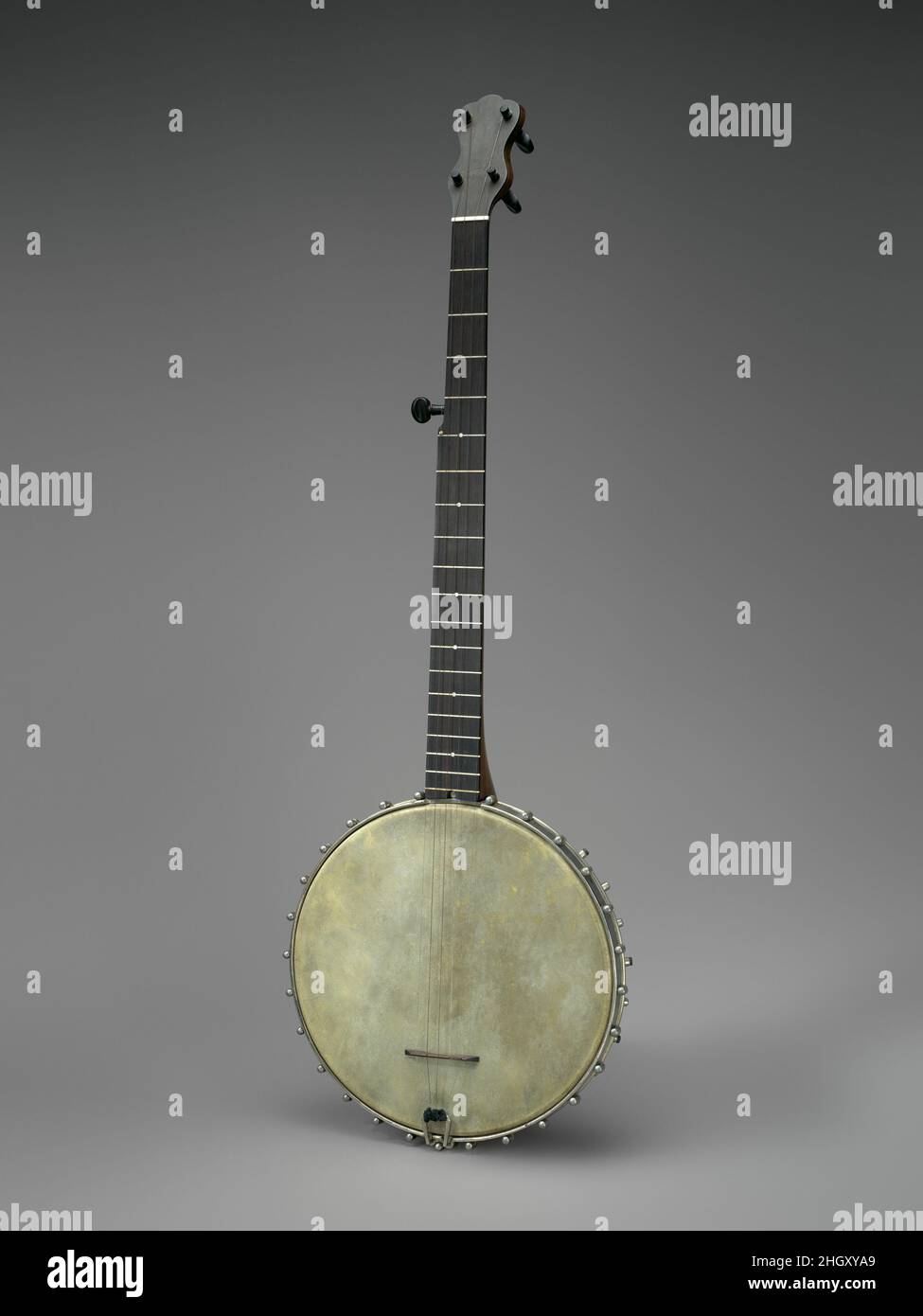 Banjo ca. 1884 Hercules McCord American Hercules McCord, a banjo maker from St. Louis, MO, produced this banjo in 1884. The neck design is conventional. However, the rim assembly, which incorporates three of McCord’s four patent innovations, ingeniously addresses several technical challenges related to rim design and head tightening assemblies. The 1880s saw major innovations in banjo design and technology. 75 patents related to banjos were registered with the U. S. Patent Office during that decade. Many of these patents focused on either the mechanisms used to tighten the skin head or the des Stock Photo