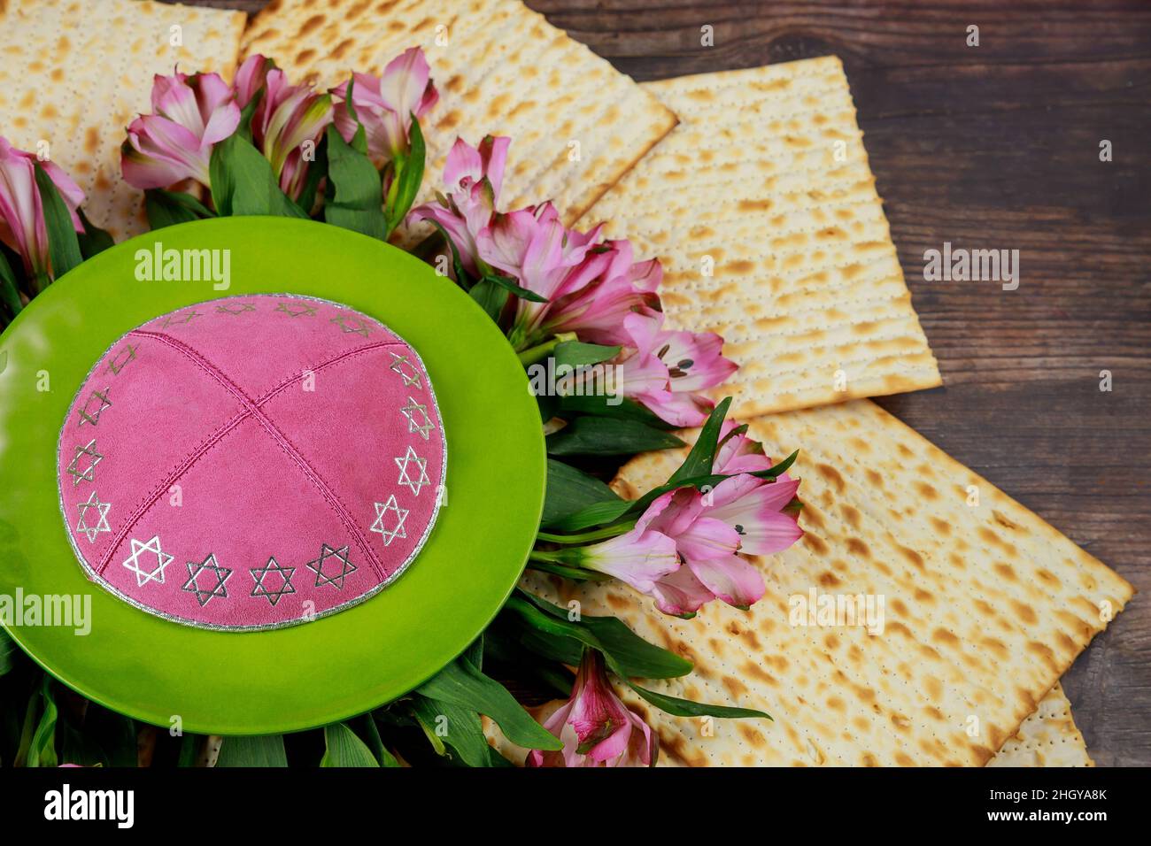 Jewish matzah bread with kippah and flowers on wooden rustic background ...