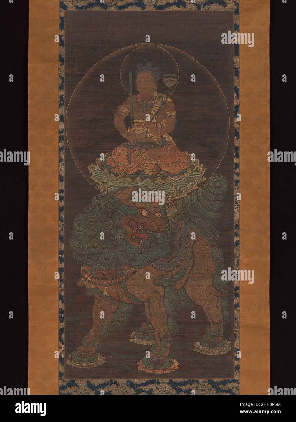 The Bodhisattva Monju (Manjushri) with Five Topknots 14th century Unidentified This painting portrays a variant form of the bodhisattva Monju known as Monju with Five Topknots (Gokei Monju). He is imagined as a boy sitting cross-legged on a lotus pedestal atop a lion. He carries a sword, used to cut through ignorance, and a lotus, above which hovers a scroll representing the Perfection of Wisdom Sutra. The five topknots symbolize five buddhas who are said to embody five types of cognition.. The Bodhisattva Monju (Manjushri) with Five Topknots. Unidentified Artist, Japanese. Japan. 14th century Stock Photo