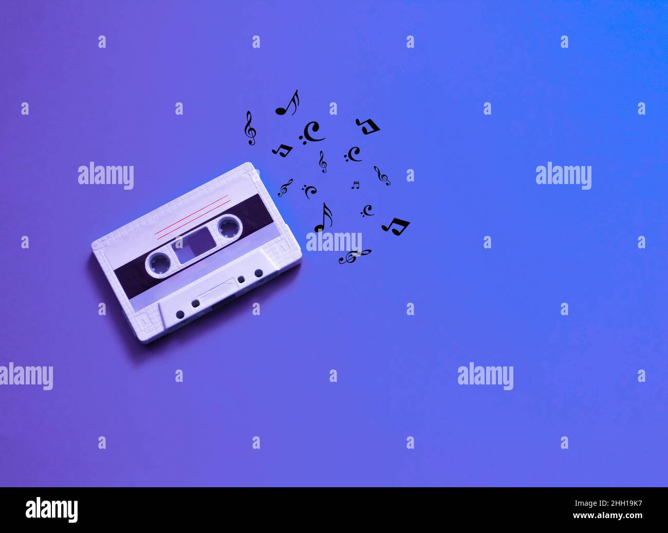 Audio cassette. Vintage white audio cassette on a colored background with notes. 80s style. retro concept Stock Photo
