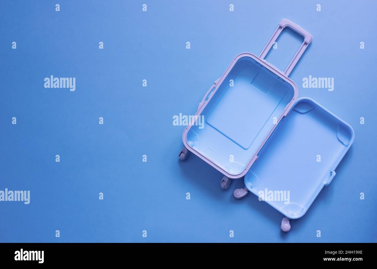Fully opened blue suitcase, on a blue background, top view. Vacation, travel concept. copy space Stock Photo