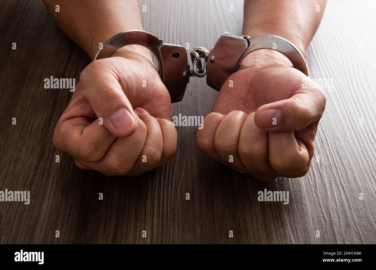 Criminal hands locked in handcuffs Stock Photo Alamy