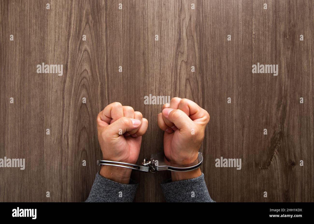 Criminal hands locked in handcuffs Stock Photo Alamy
