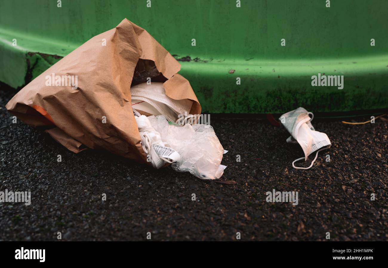 Used medical face mask discard on floor. Medical waste disposal with unhygienic. Face mask waste garbage on floor. Dirty white surgical face mask Stock Photo