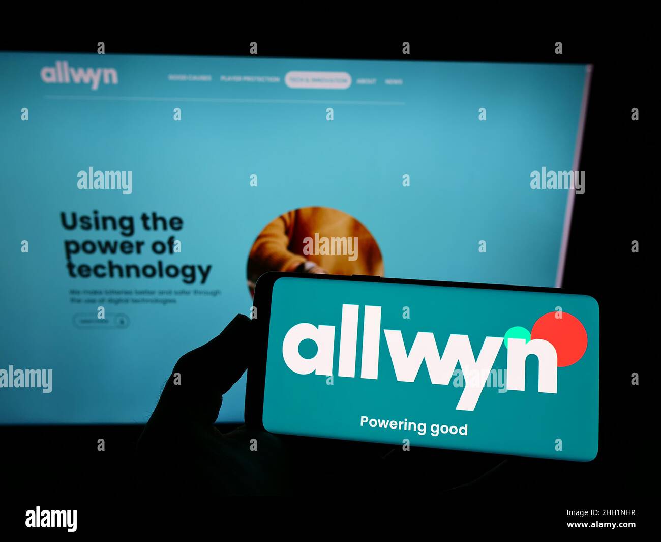 Person holding smartphone with logo of company SAZKA Entertainment AG (Allwyn) on screen in front of website. Focus on phone display. Stock Photo