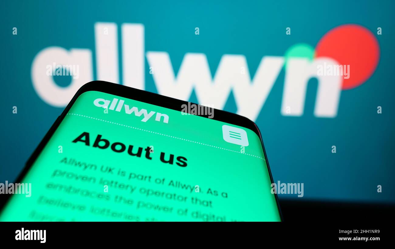 Smartphone with website of company SAZKA Entertainment AG (Allwyn) on screen in front of business logo. Focus on top-left of phone display. Stock Photo