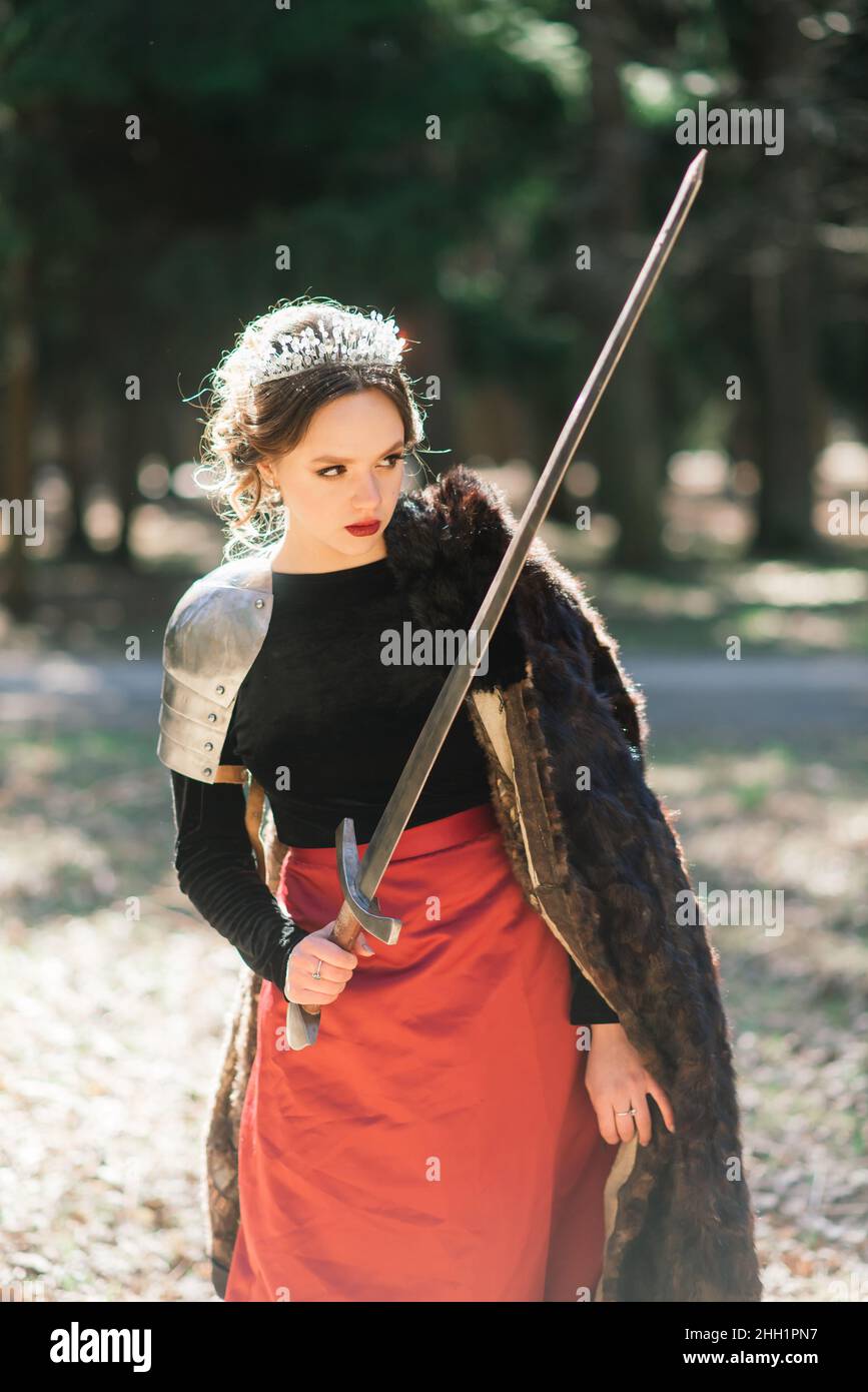 Armed medieval woman warrior in armor posing while standing on ...