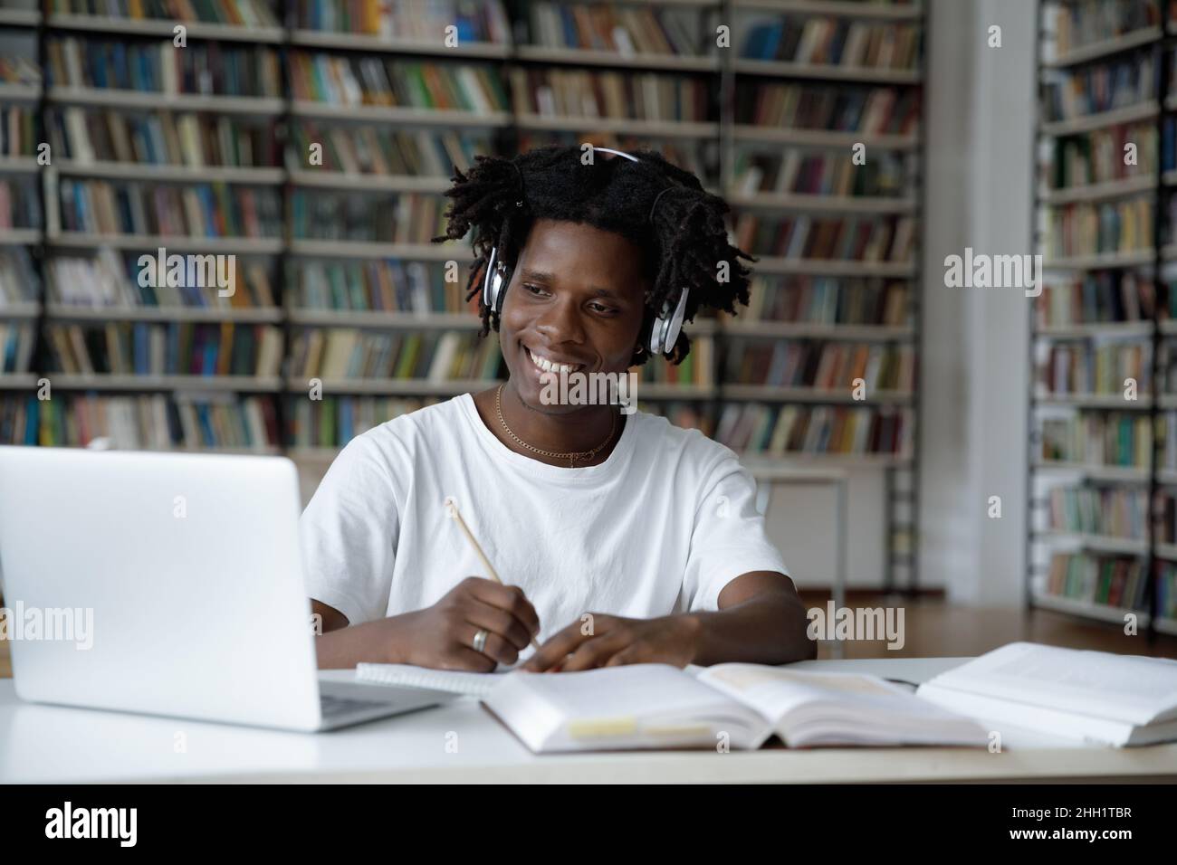 Cheerful student guy enjoying studying in college library Stock Photo
