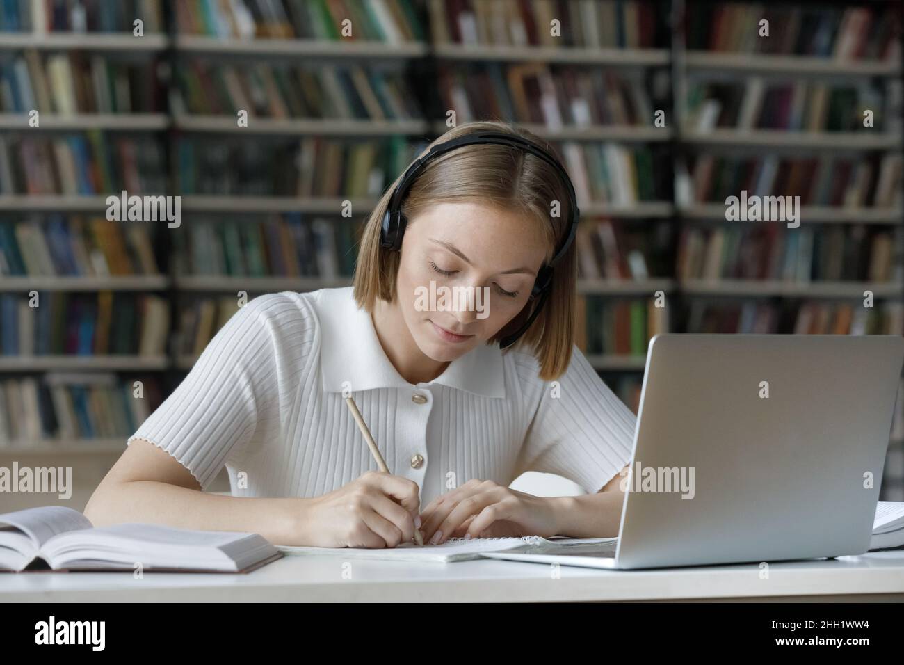 Serious student girl listening to audio tutorials from wireless ...