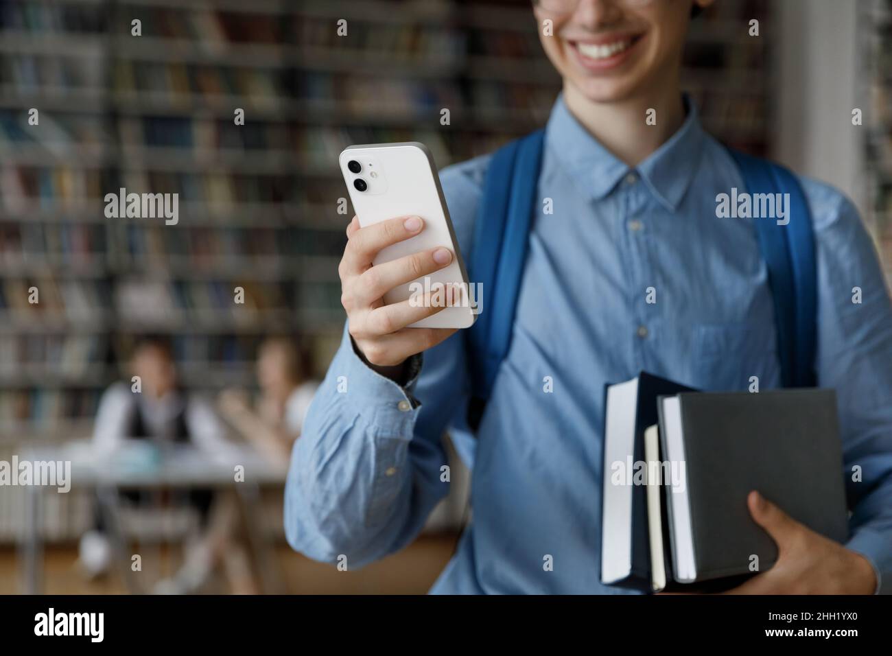 Happy student guy using online app, internet service on smartphone Stock Photo