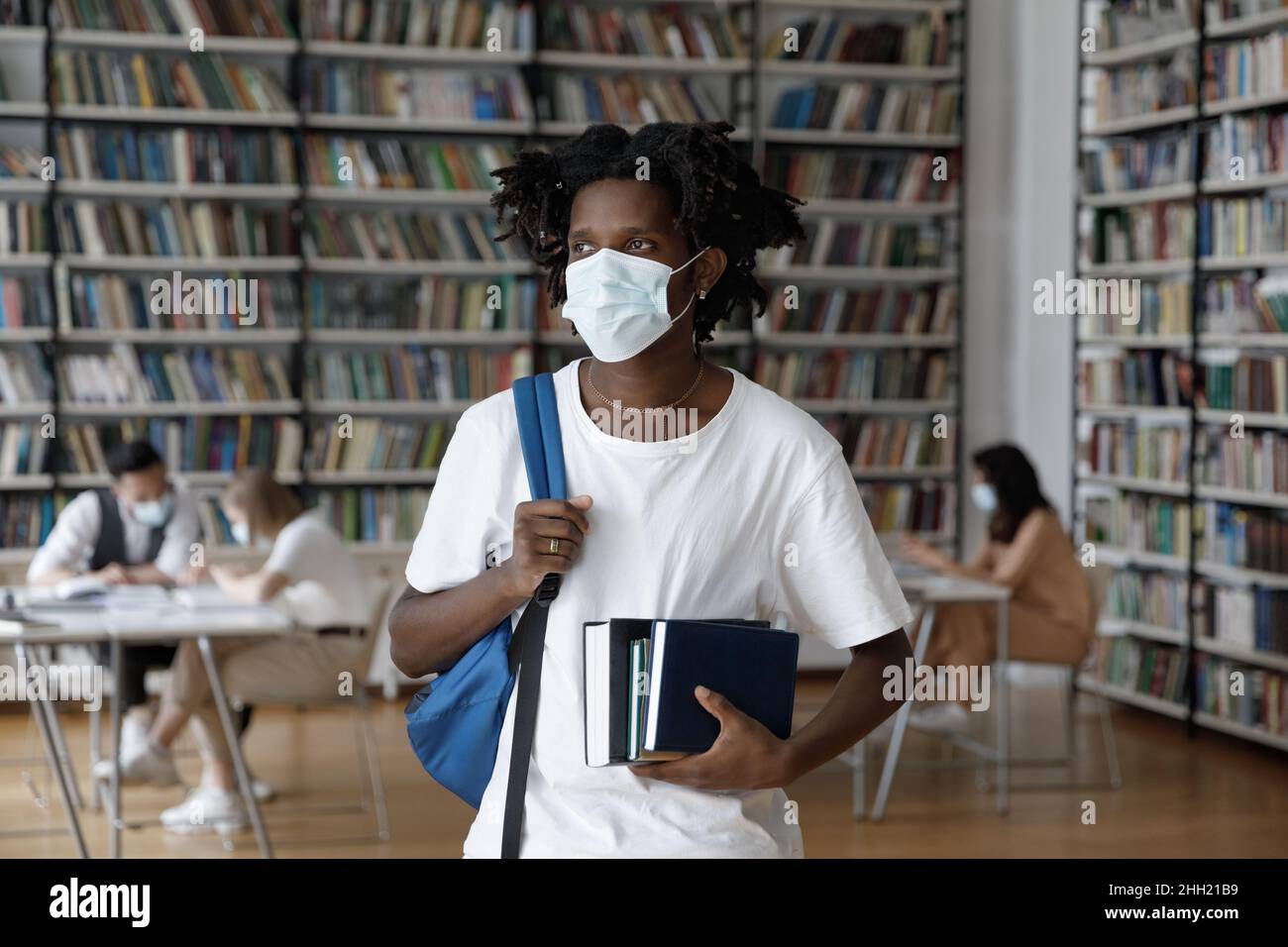 Thoughtful African student guy in mask staying safe from infection Stock Photo