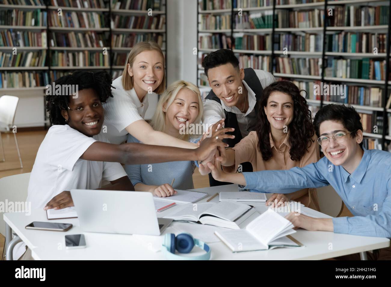 Mixed race team of happy students giving group high five Stock Photo ...
