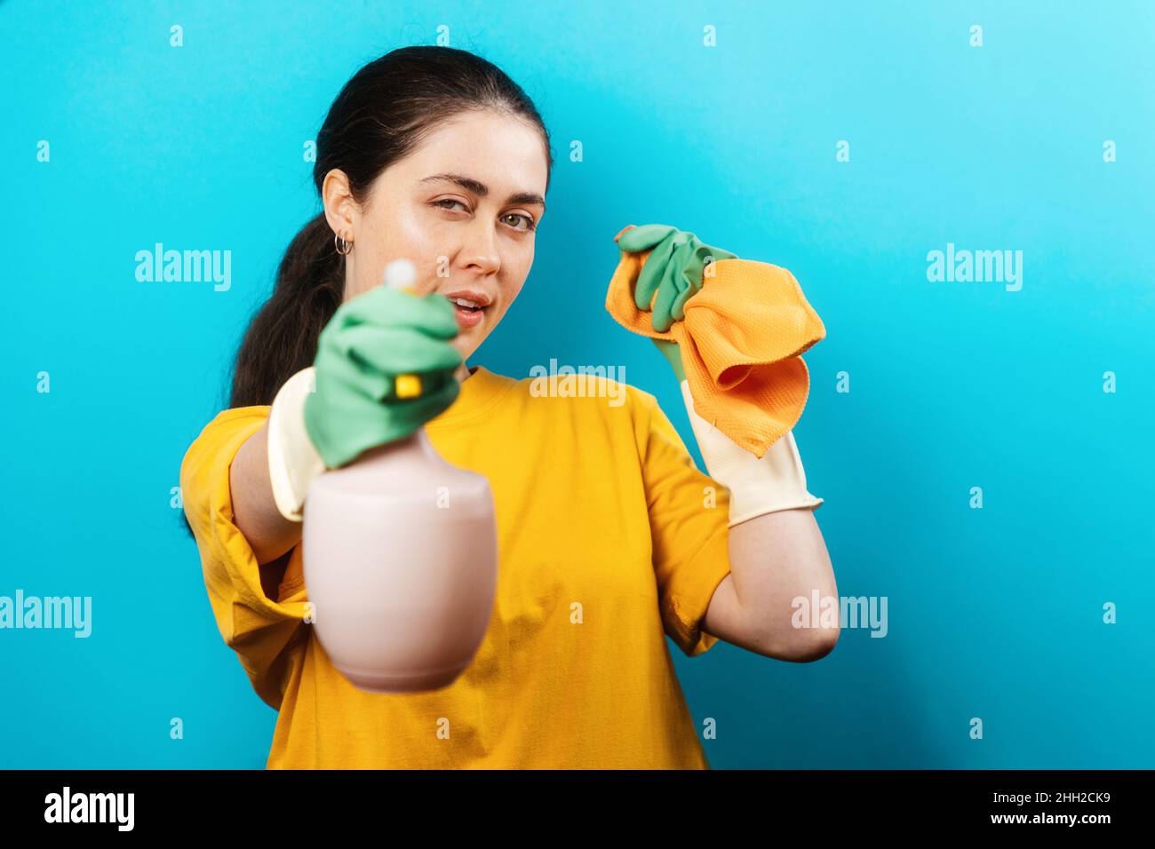 Portrait of a beautiful Caucasian young woman in rubber gloves, holding ...