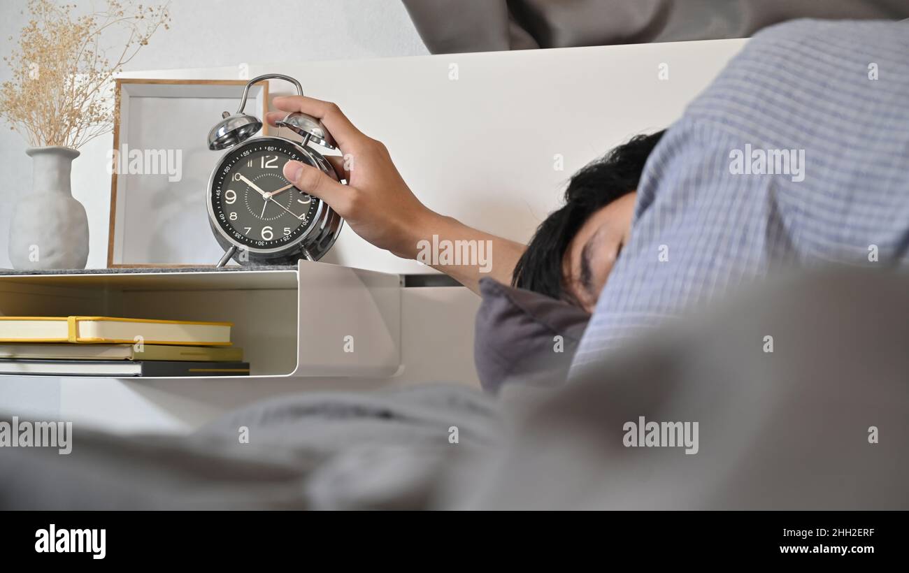 Male turning off alarm clock hi-res stock photography and images - Alamy