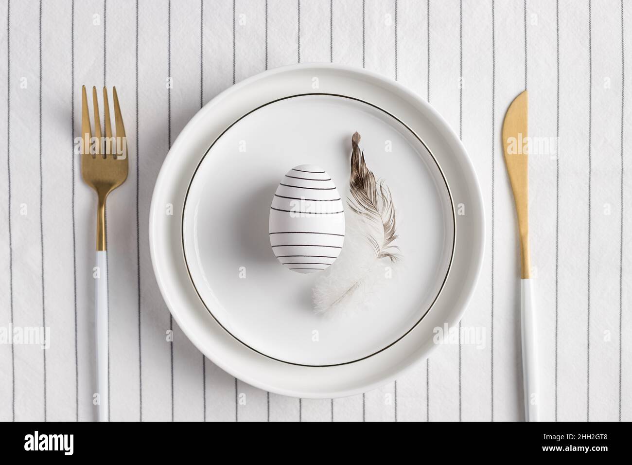Stylish festive Easter table setting. White plate with decoration Stock Photo