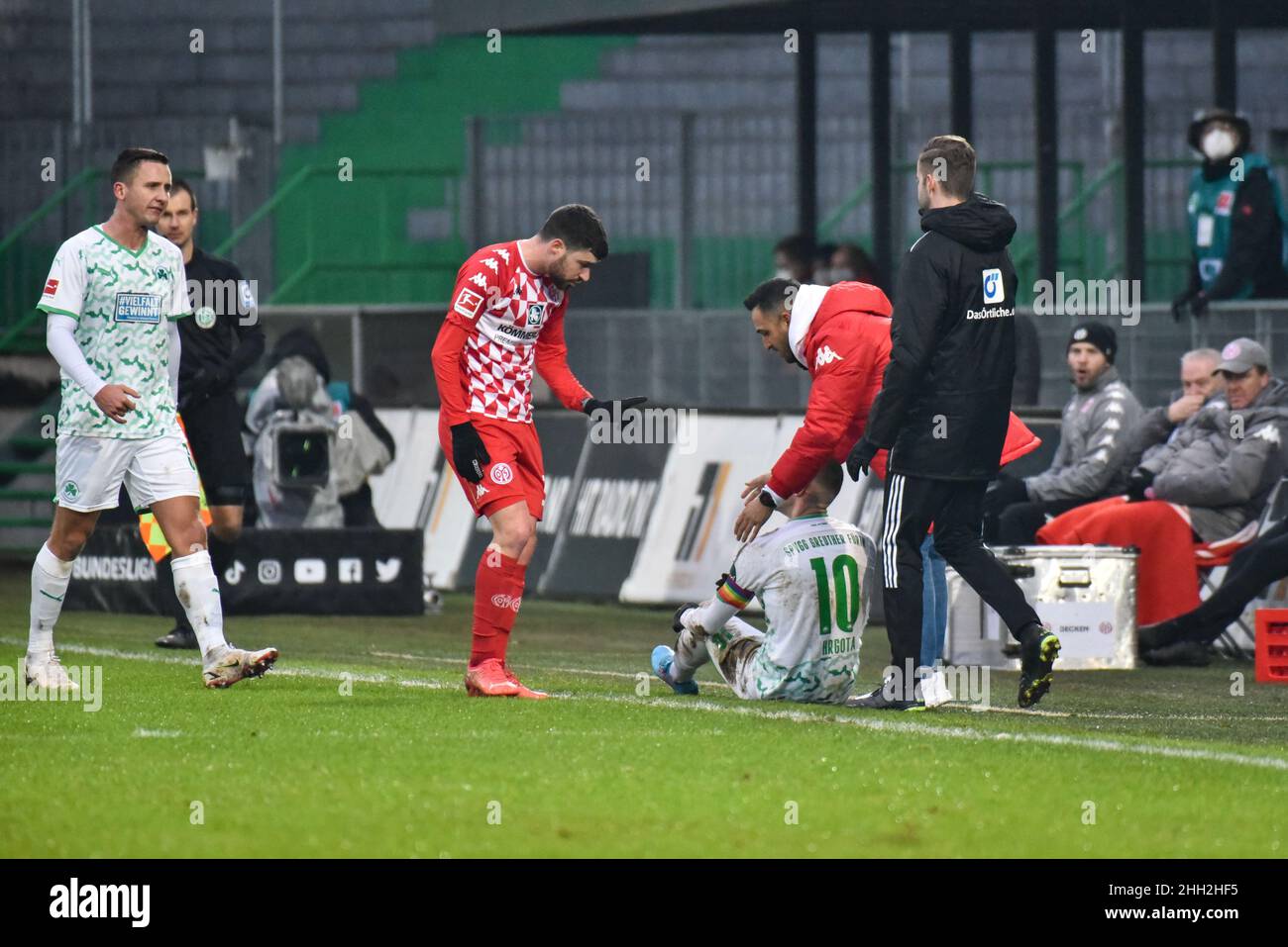 Germany ,Fuerth, Sportpark Ronhof Thomas Sommer - 22 Jan 2022 - Fussball, 1.Bundesliga - SpVgg Greuther Fuerth vs. FSV Mainz 05  Image: Branimir Hrgota (SpVgg Greuther Fürth,10) sitting on the ground after being fouled; Aaron Martin (Mainz, 3) making a hand gesture indicating that he didn’t foul him.  DFL regulations prohibit any use of photographs as image sequences and or quasi-video Stock Photo