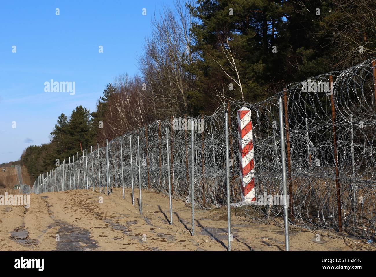 18 January 2022, Poland, Usnarz Gorny: A temporary barbed wire fence stands near the village of Usnarz Gorny in the exclusion zone on the border between Poland and Belarus. The fence is intended to keep out migrants who want to enter the EU from Belarus. Soon, Poland plans to start building a 5.5-meter-high barrier. (to dpa: 'Border with Belarus: In the exclusion zone, the border guards command') Photo: Doris Heimann/dpa Stock Photo