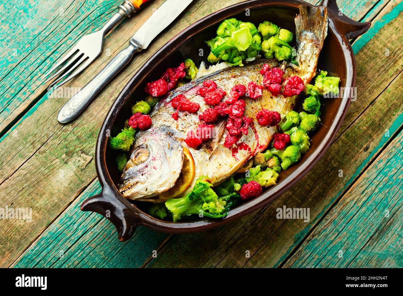 Delicious sea bream baked with raspberries and broccoli Stock Photo - Alamy