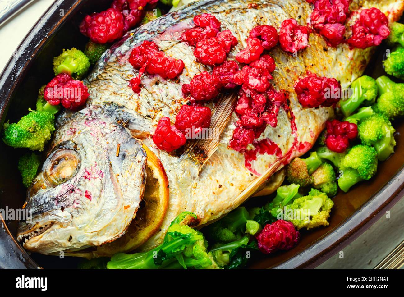 Delicious sea bream baked with raspberries and broccoli. Dorado fish ...