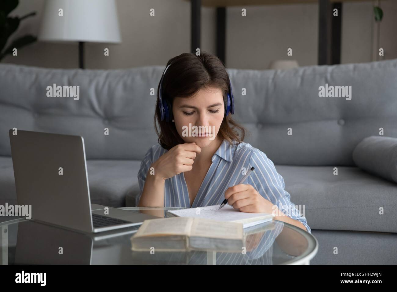 Focused millennial woman studying on online courses. Stock Photo