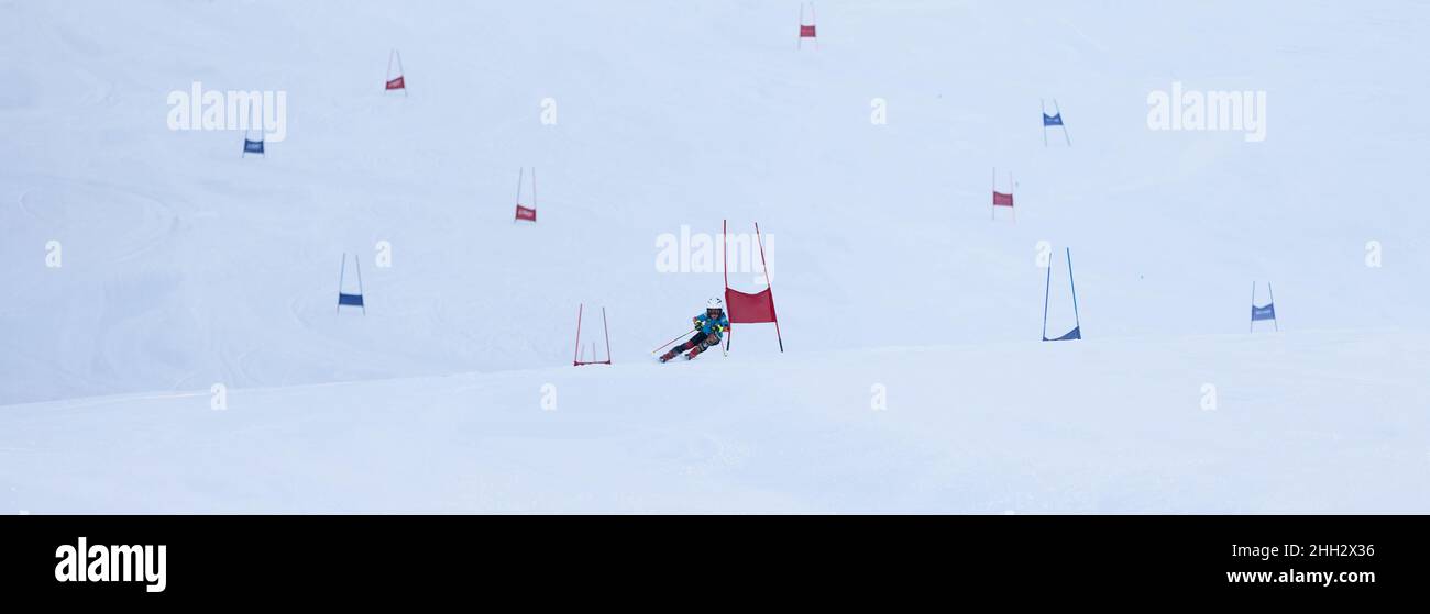 Young boy skiing high speed in a slalom track. Alpine skiing and winter sports. Stock Photo