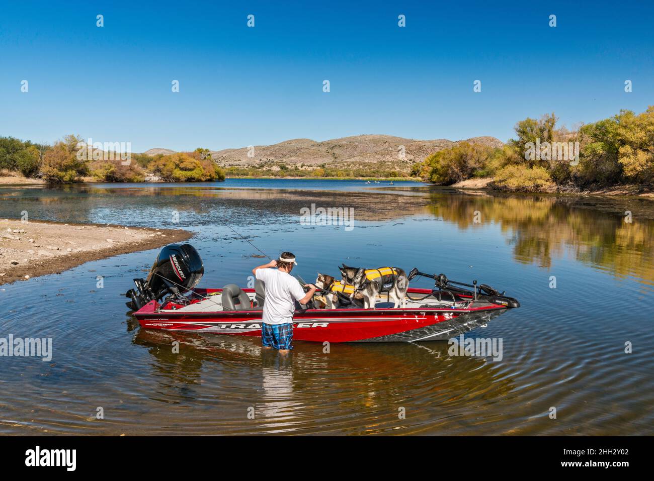 Man wading, speedboat at Arivaca Lake, Atascosa Mountains, Coronado National Forest, Arizona, USA Stock Photo
