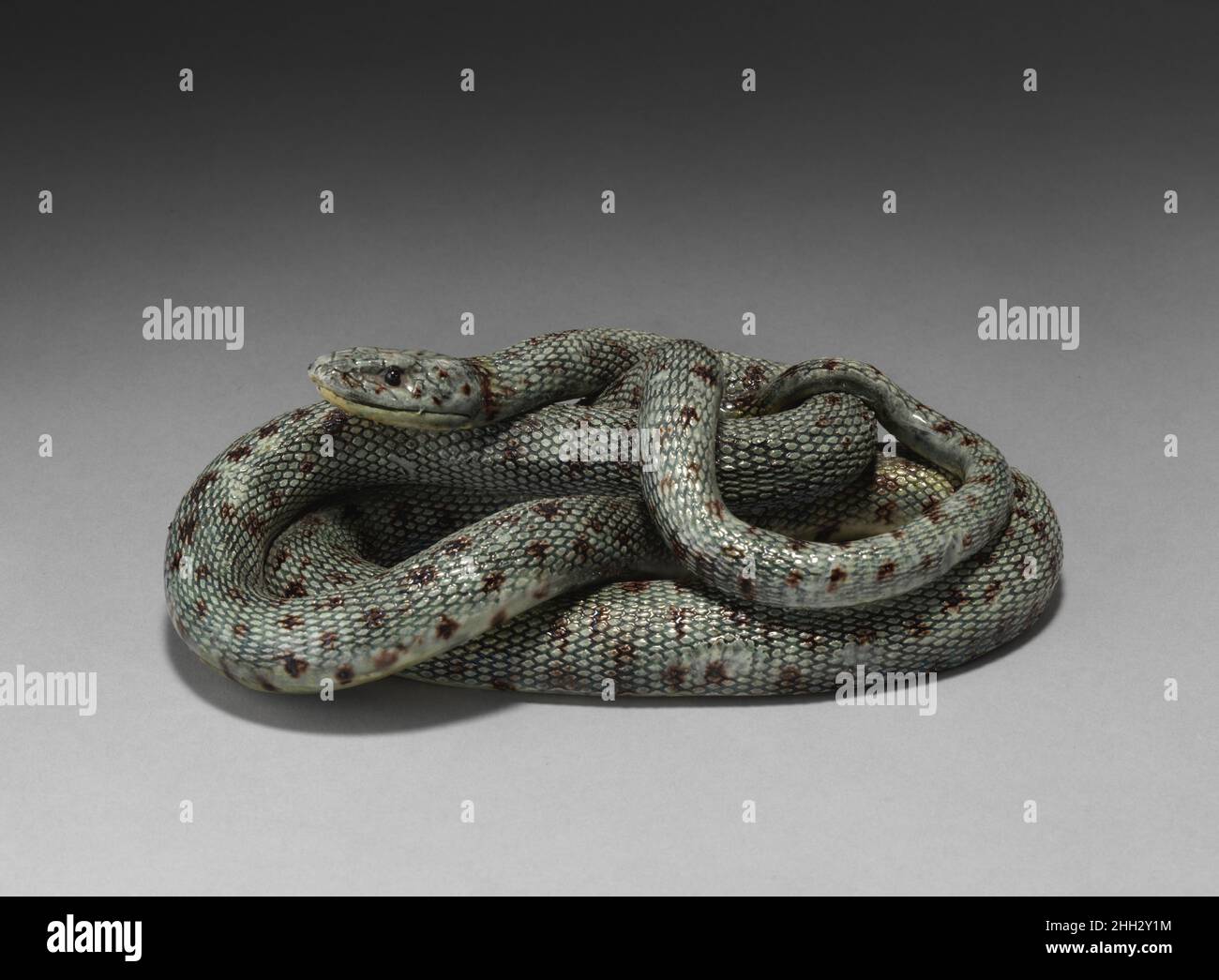 Snake ca. 1870–1880 Saint-Honoré-les-Bains Snakes often featured on Palissy ware dishes and basins of the nineteenth century, typically placed in the center of compositions. This example of a glazed snake suggests that some factories may have made the reptiles as collectible figurines. Snake. French, possibly St. Honoré-les-Bains. ca. 1870–1880. Glazed earthenware. Ceramics-Pottery Stock Photo