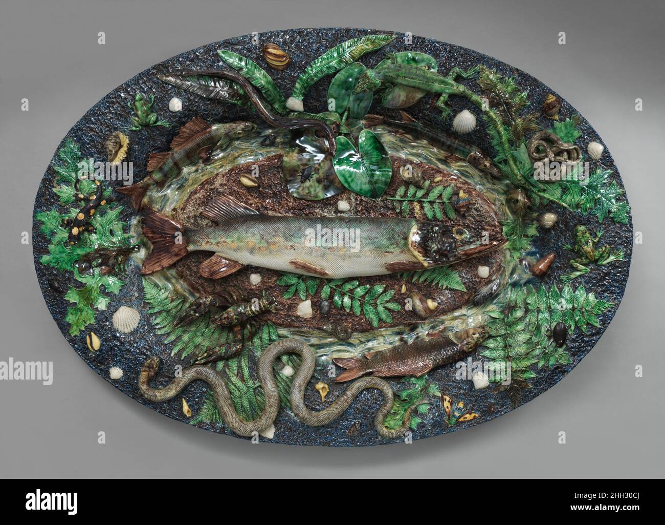 Large Platter with Fish ca. 1855–1875 Probably made by Victor Barbizet Though the fish and other aquatic creatures shown on this dish are certainly inspired by the work of the Renaissance potter Bernard Palissy, the impressive scale of this nineteenth-century platter suggests that it was probably intended for a large exhibition venue, possibly a universal exhibition. In 1878, Achille earned a silver medal at the Paris Universal Exhibition.. Large Platter with Fish. French. ca. 1855–1875. Glazed earthenware. Ceramics-Pottery Stock Photo