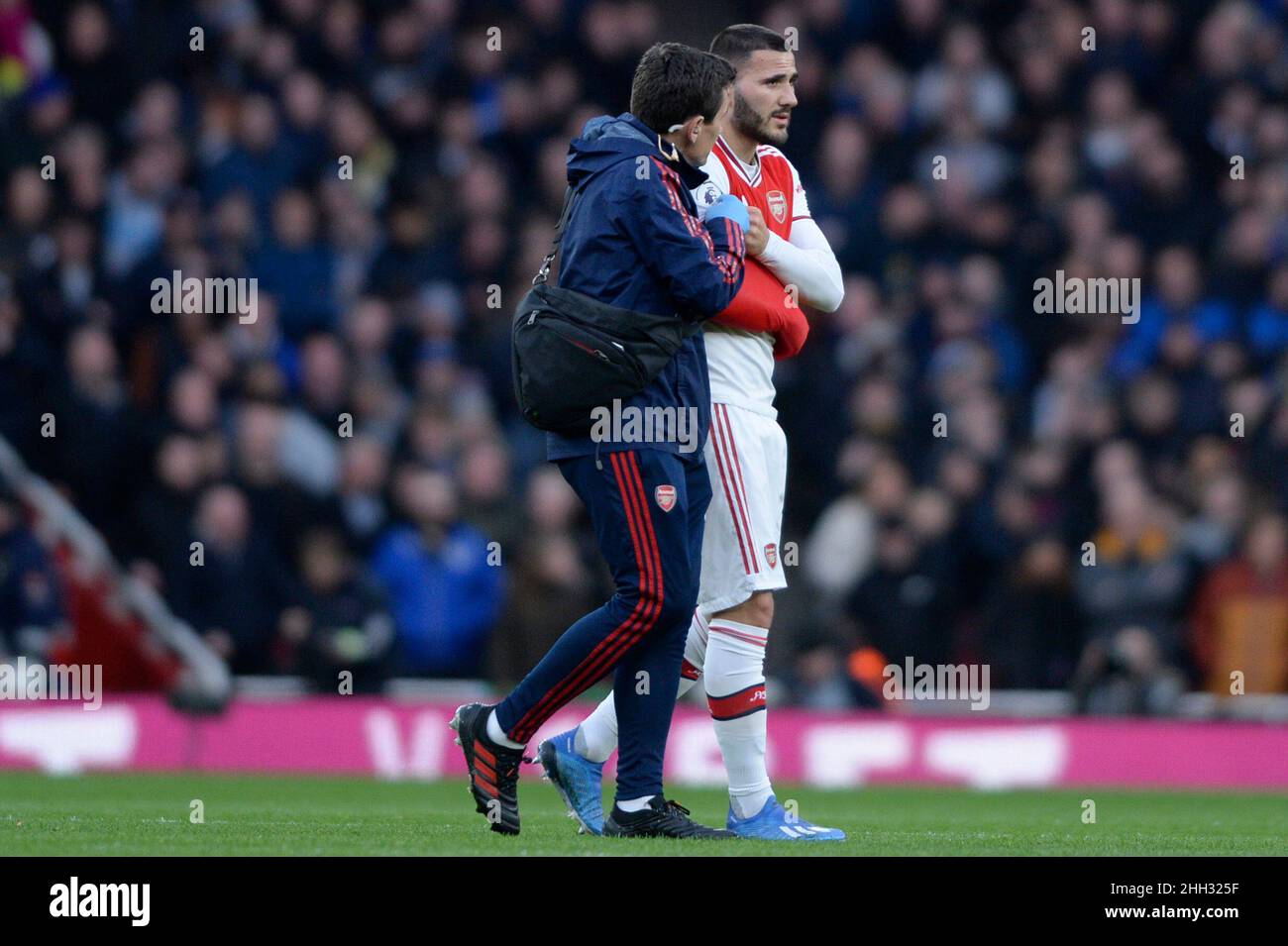 Sead Kolasinac of Arsenal leaves the pitch after suffering an injury during the Premier League match between Arsenal and Everton at the Emirates Stadium in London, UK - 16th February 2020 Stock Photo