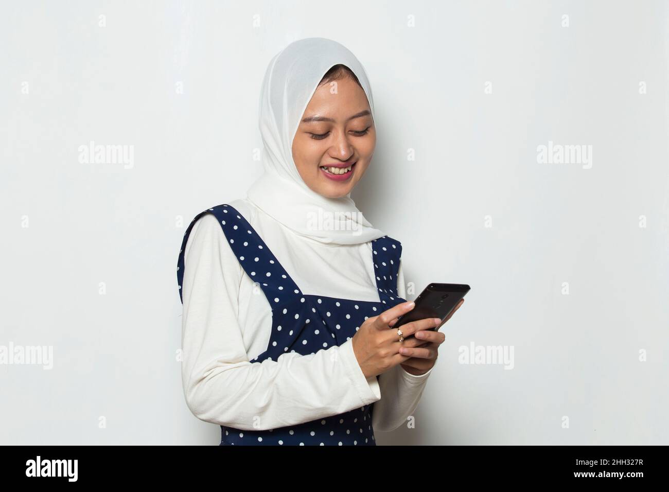 happy young asian muslim woman using mobile phone isolated on white ...