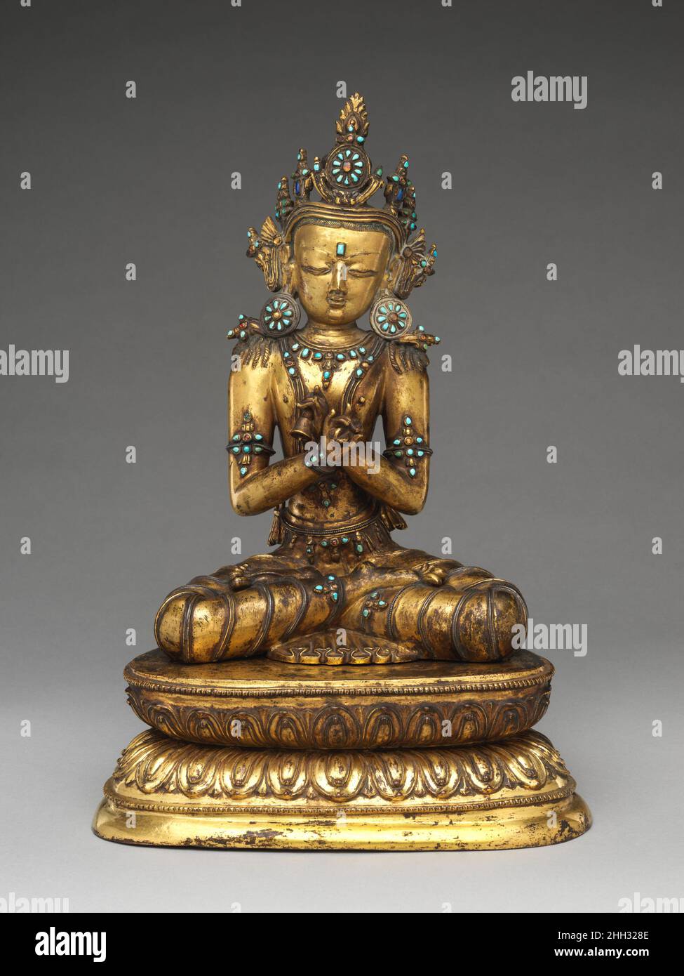 The Primordial Buddha Vajradhara 15th century Tibet The Buddha Vajradhara is a divine manifestation of the totality of Buddhist teachings and is credited with being the source of the Buddhist tantric texts. Here, he holds a vajra and a bell that symbolizes energy (male) and emptiness (female). This sculpture is remarkable for the many surviving original inset pieces of turquoise and semiprecious stones and for the silver wire inlay in his dhoti (loincloth). These components indicate his divine status and evoke the crystalline nature of the heaven where he resides.. The Primordial Buddha Vajrad Stock Photo