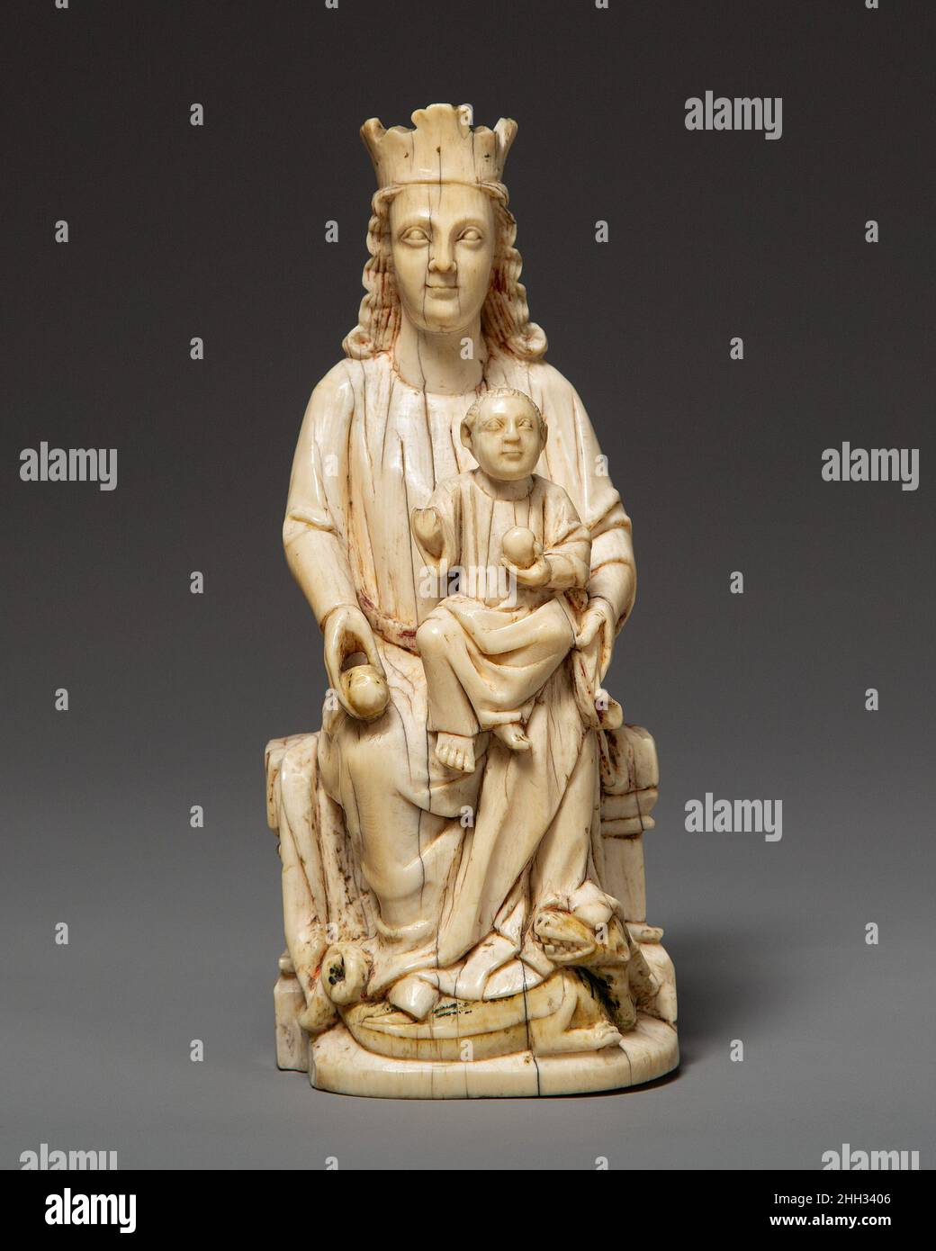 Enthroned Virgin and Child ca. 1200–1250 Spanish Although many ivory statues from medieval France survive, this enthroned Virgin and Child is a rare example from Spain. The wide open eyes, straight nose, rounded chin, and thick neck are typical of thirteenth- and fourteenth-century representations from the old kingdoms of Léon and Navarre. Both Virgin and Child are shown holding spherical objects (apples or orbs), symbols of authority that allude to Jesus as the new Adam and Mary as the new Eve. The Virgin is victorious; the devil in the form of a dragon lies vanquished under her feet.. Enthro Stock Photo
