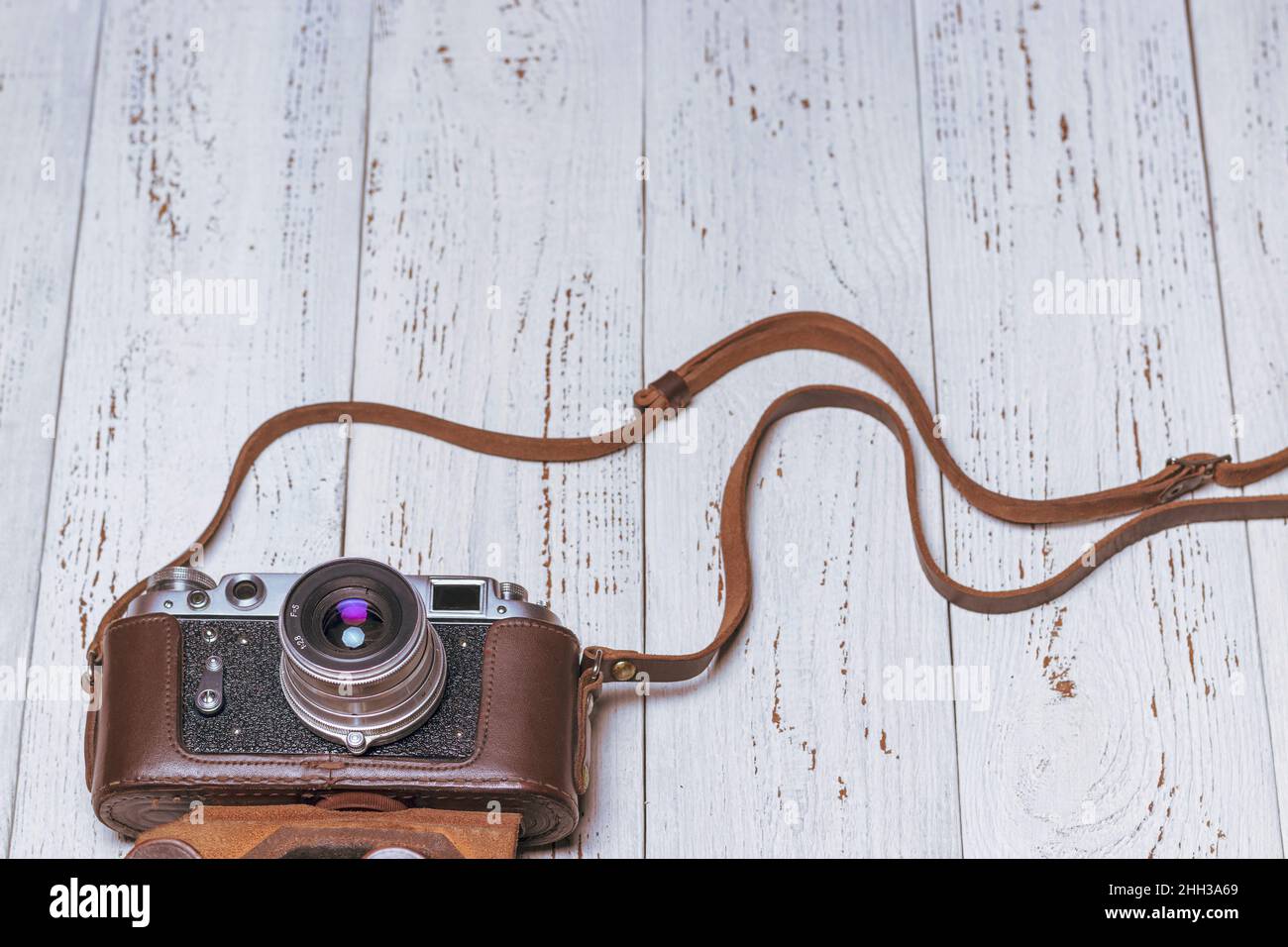 Old retro camera in a brown leather case. Background from vintage