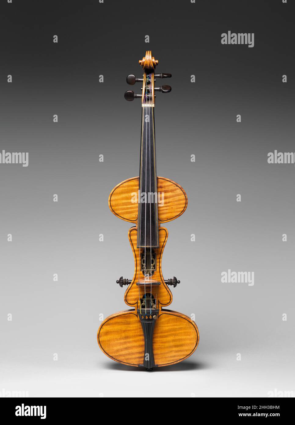 Mute Violin ca. 1886 Charles Francis Albert, Sr. Mute violins have been used as practice instruments and for special acoustical effect since the seventeenth century. Leopold Mozart used the term 'Brettgeige,' or 'board violin,' to describe a mute violin consisting of a curved board without a soundbox. Patented in 1886, this unusually shaped mute violin has a body made entirely of maple, a wood that does not vibrate freely. The bridge height can be adjusted by two pegs located on either side of the body.. Mute Violin. American. ca. 1886. Maple, ebony, brass, various other materials. Philadelphi Stock Photo