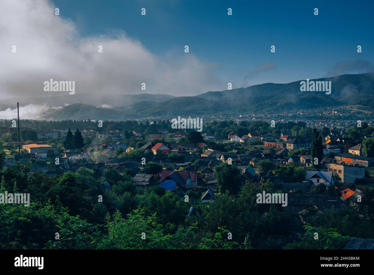 Aerial view of the village at Carpathian Mountains, Ukraine on sunrise. Summer landscape, white fog and blue sky Stock Photo