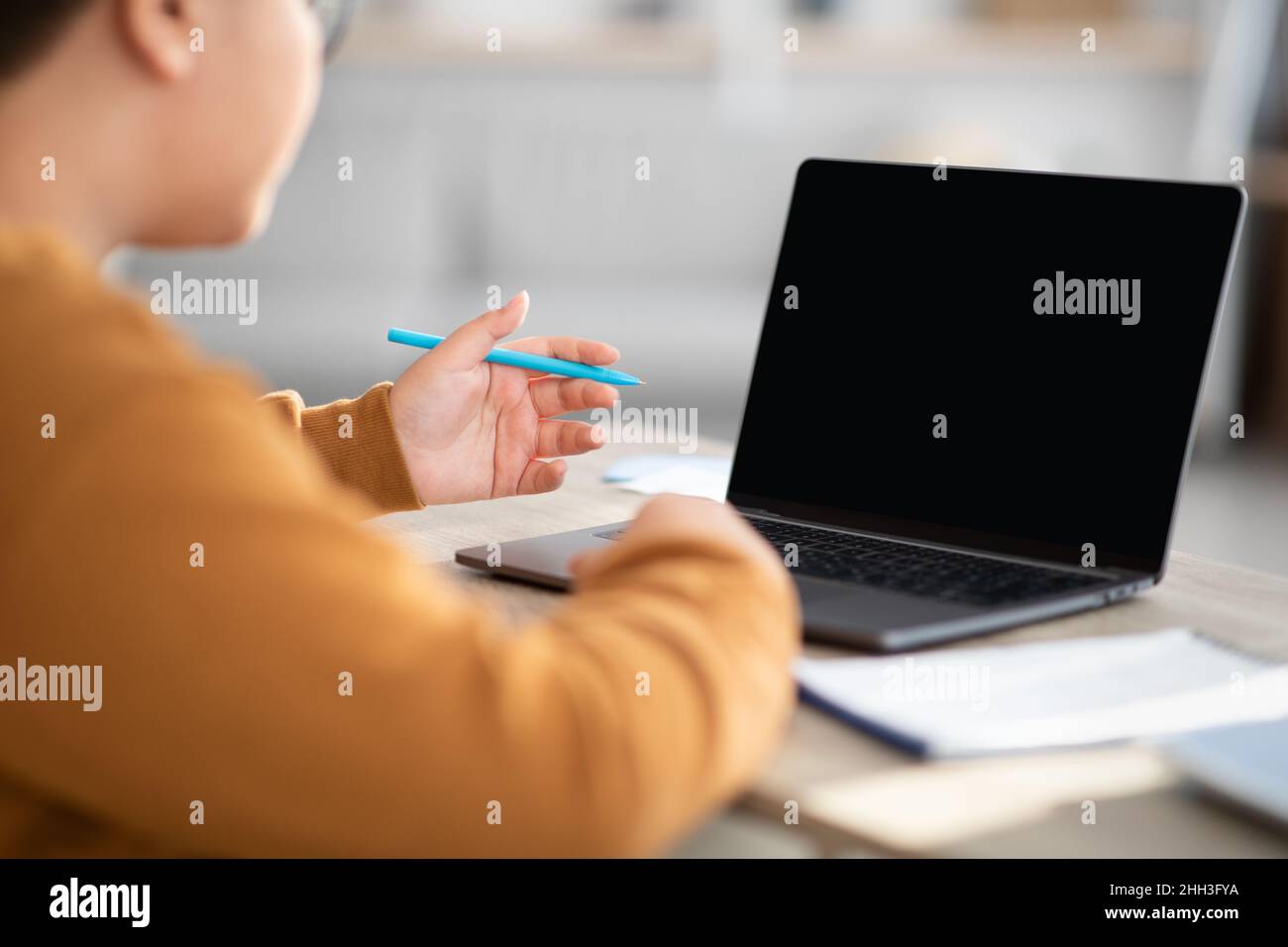 Over shoulder shot of chubby boy using notebook, mockup Stock Photo