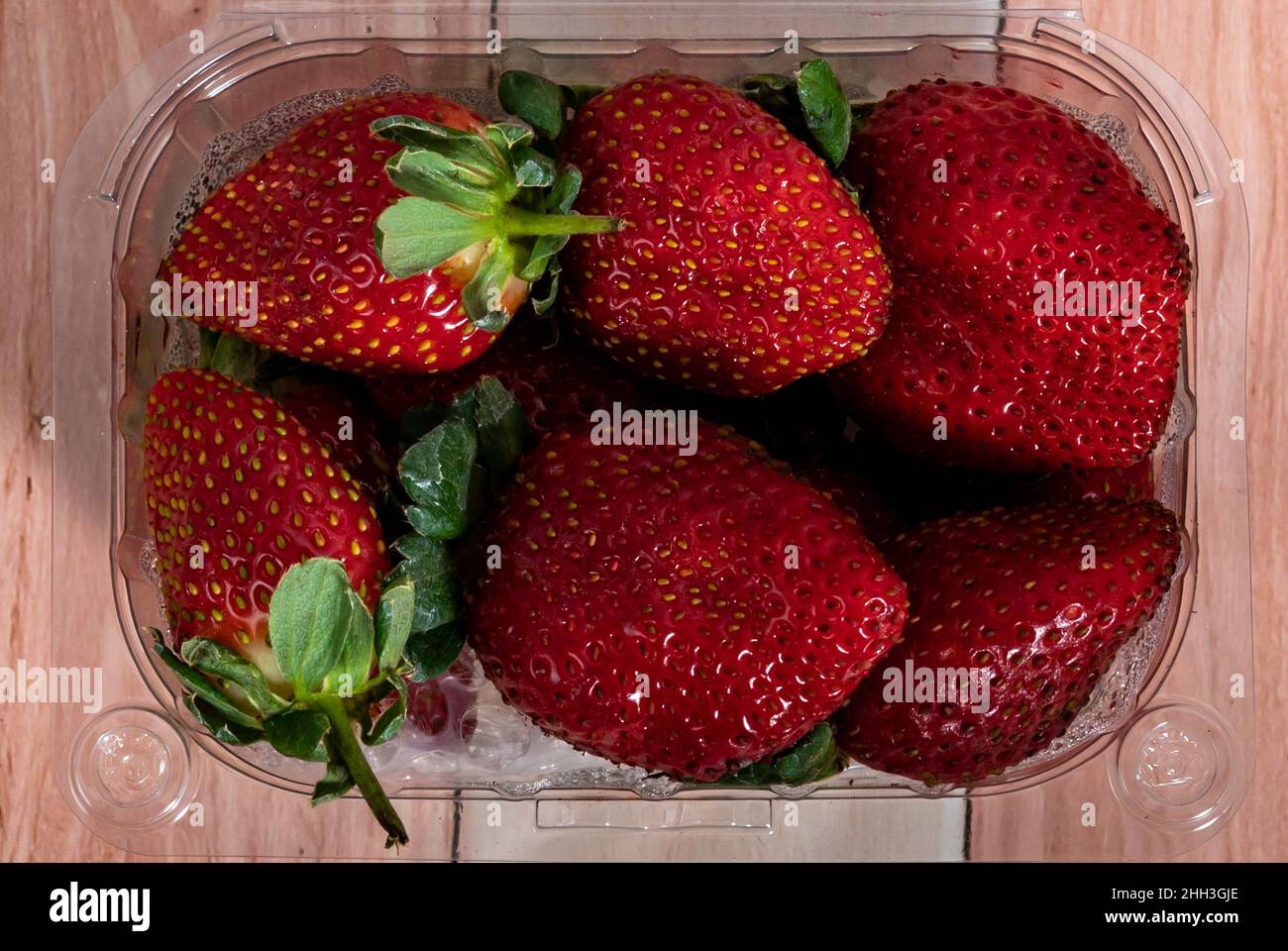 Red ripe strawberries with green stems in a plastic tray close-up Stock ...