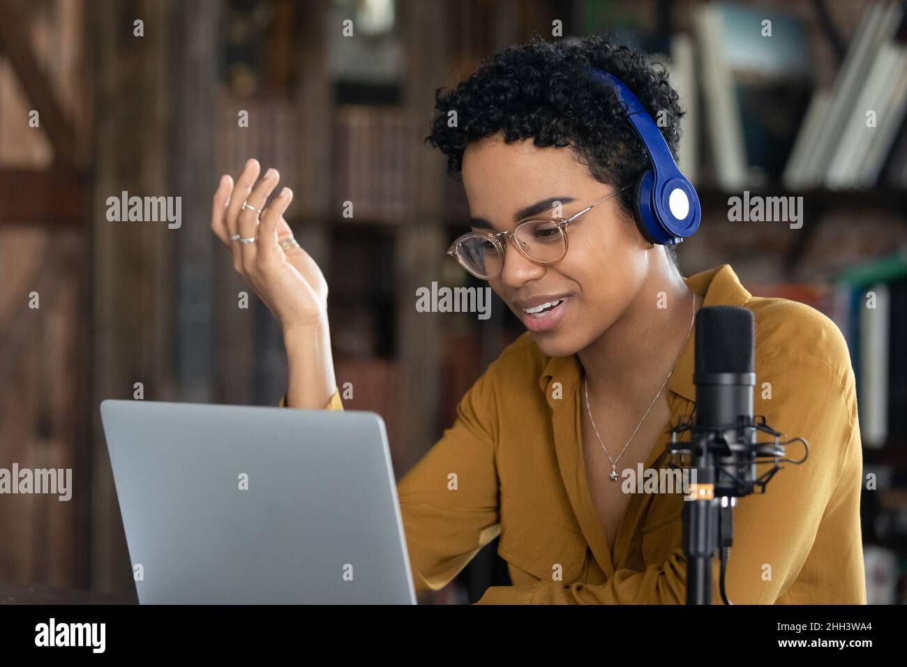 Happy African blogger girl in headphones shooting online training Stock Photo