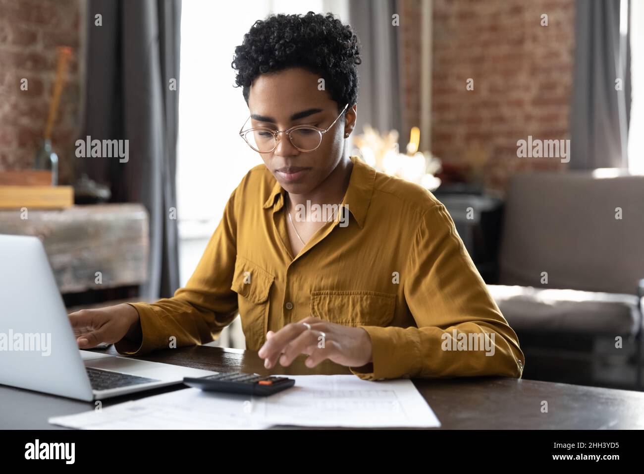 Focused millennial Black business woman calculating finance Stock Photo