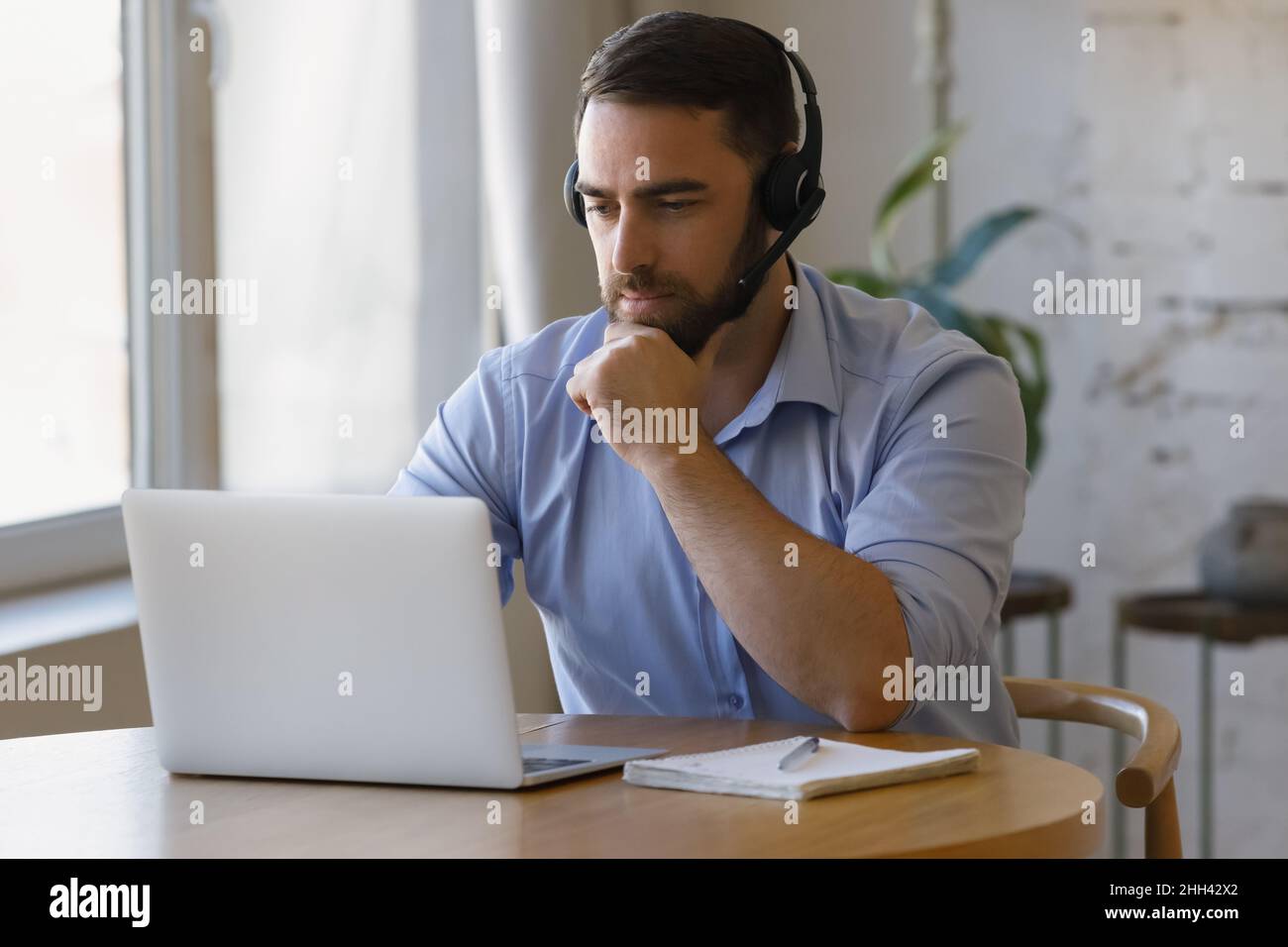 Millennial distant worker in headphones working from home Stock Photo