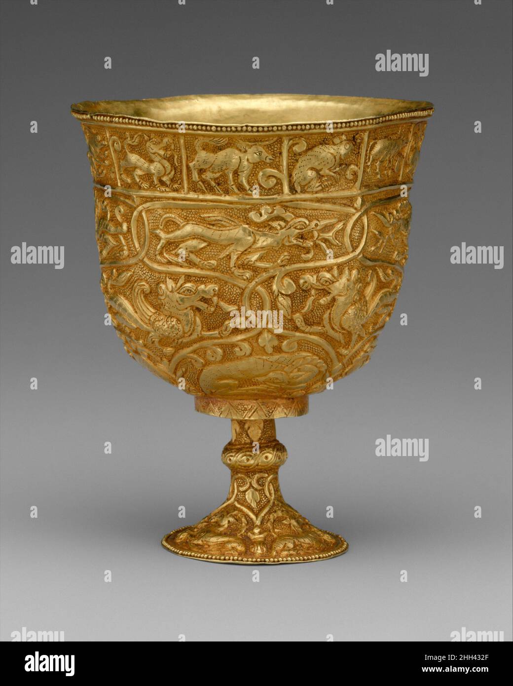 Stem Cup 7th–9th century China (Xinjiang Autonomous Region, Central Asia) The intertwined vine with its curled leaves is reminiscent of Sogdian imagery and motifs found in Gandharan Dionysian reliefs. The twelve animals of the Chinese zodiac are placed in rectangular frames beneath the cup rim.. Stem Cup. China (Xinjiang Autonomous Region, Central Asia). 7th–9th century. Gold with repoussé decoration. Period of Tibetan Empire. Metalwork Stock Photo