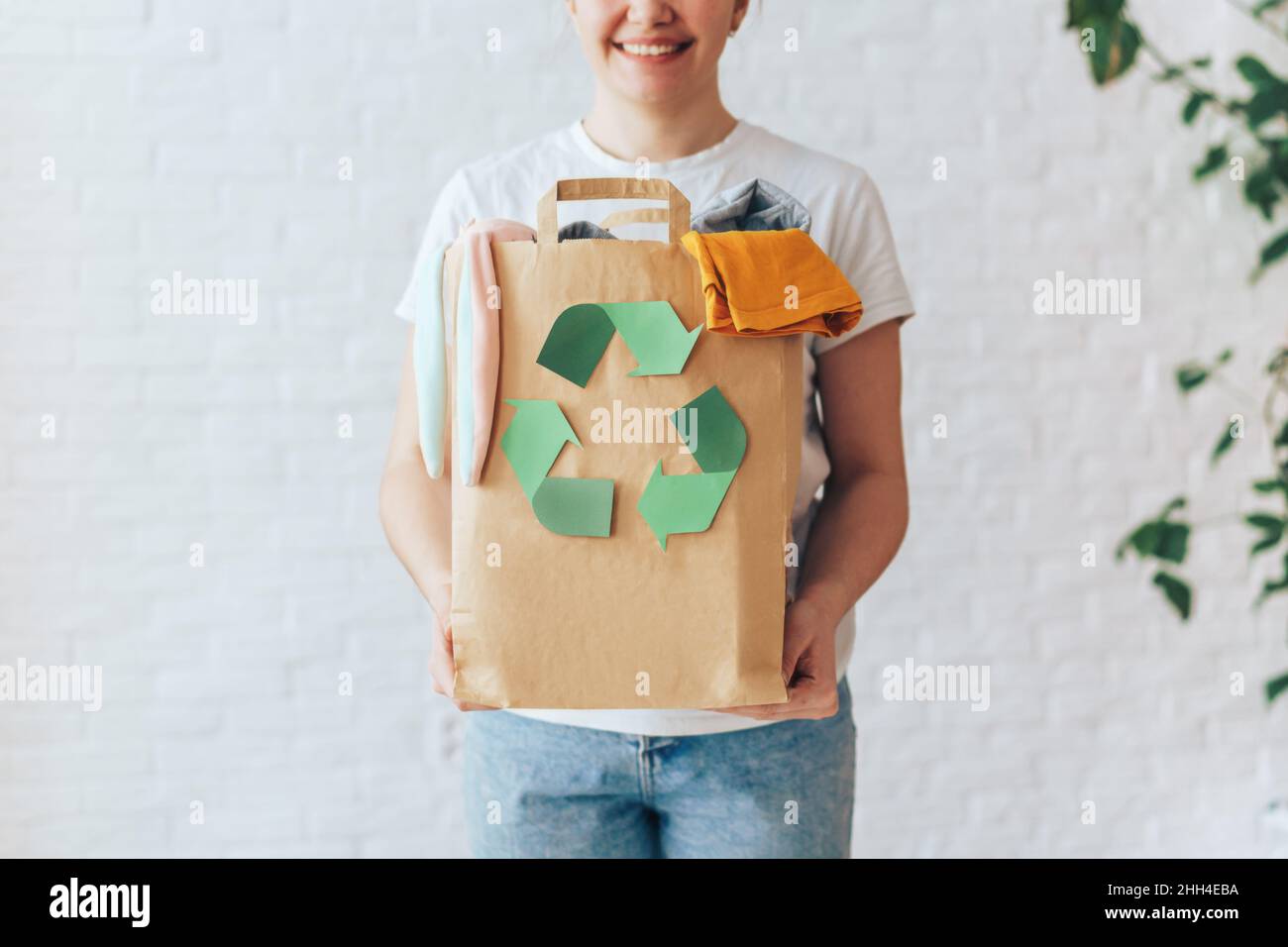Girl holding paper bag with old clothes for recycling Stock Photo Alamy